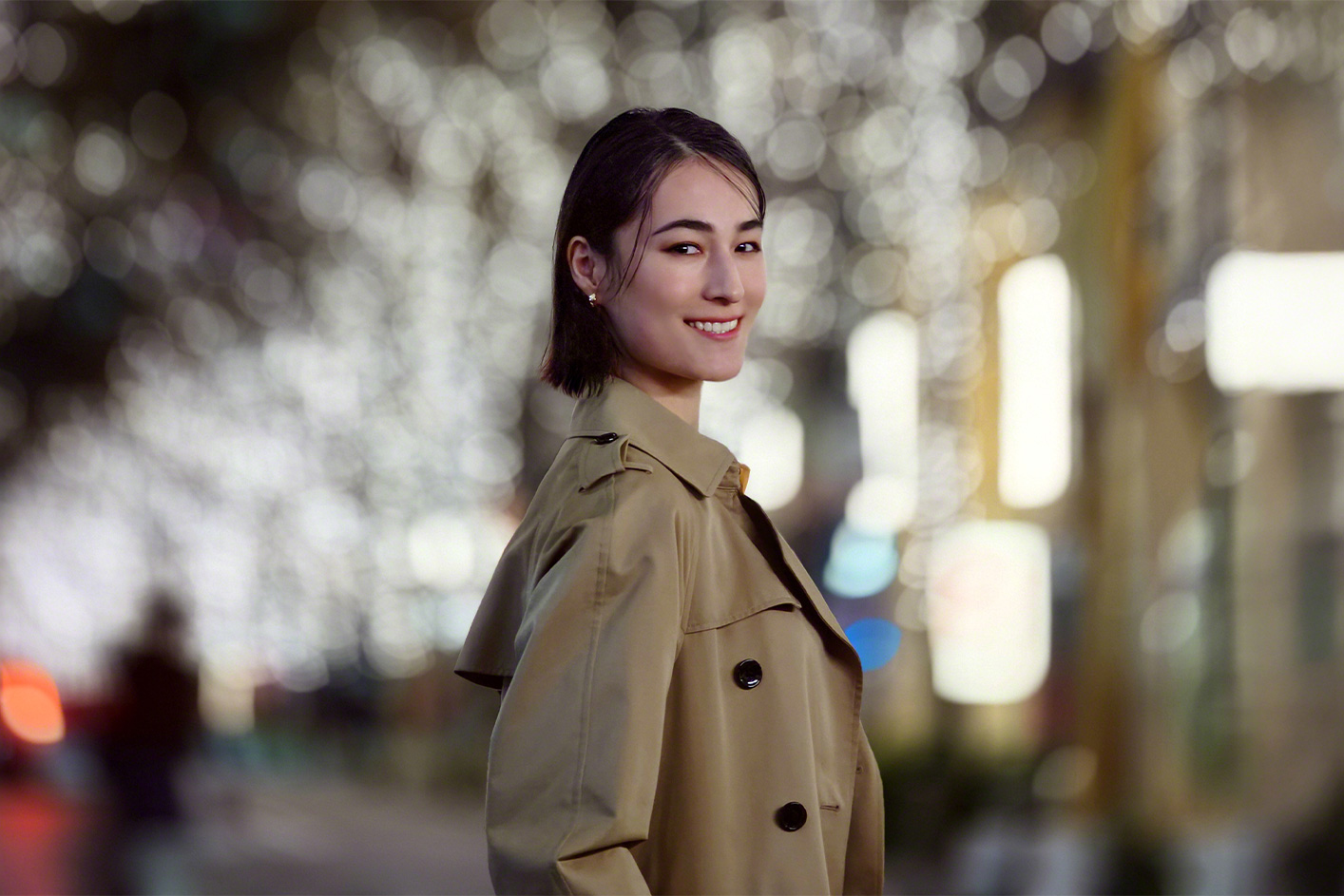 A person smiling against a blurry background